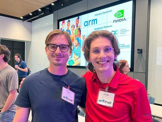 A man in a blue shirt and a man in a red shirt pose for a photo.