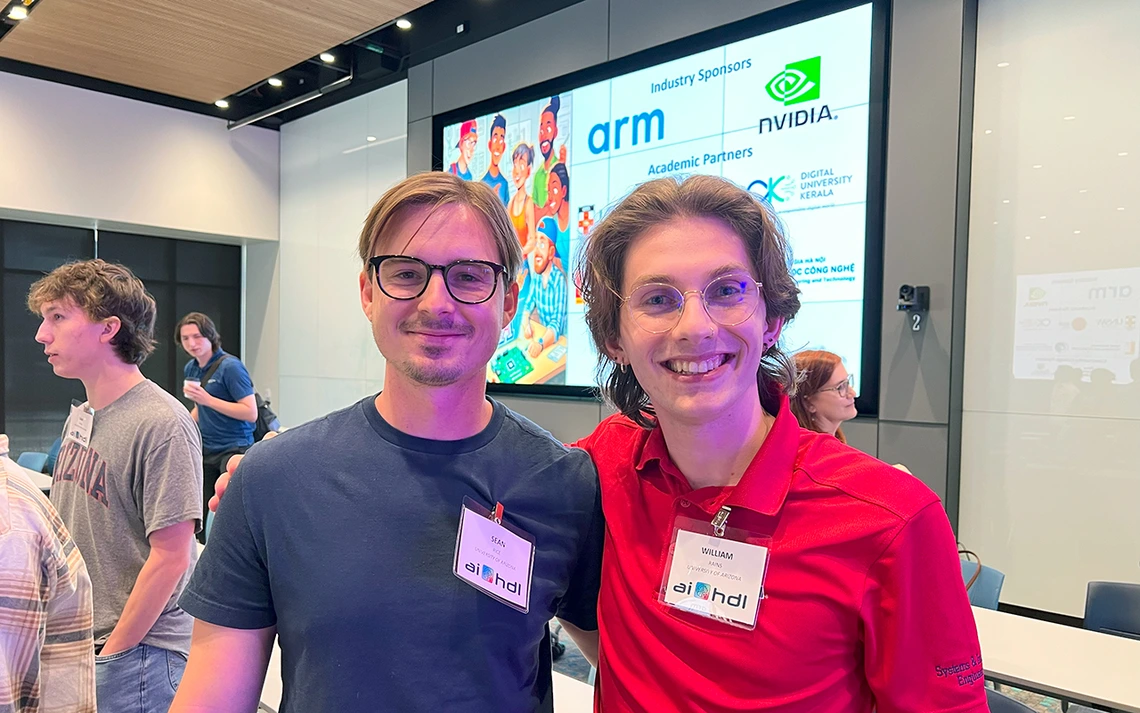 A man in a blue shirt and a man in a red shirt pose for a photo.