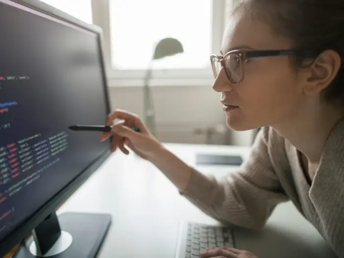 Woman examines code on a computer screen